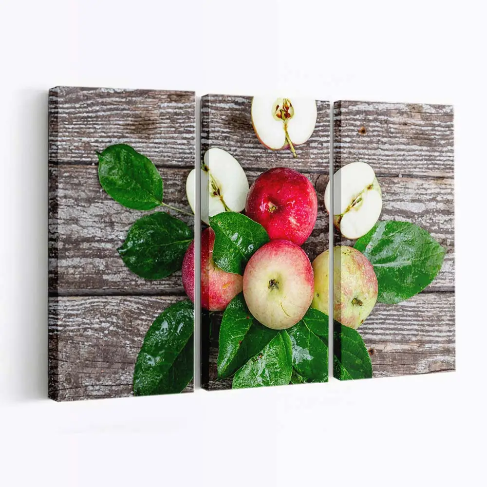 Frische Äpfel mit Blättern auf Holztisch Leinwandbild